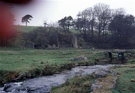 Nigel on the clapper bridge with some of the ruined buildings behind