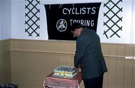 Les Sparkes, president of the Devon DA, cuts the anniversary cake at Kenton Village Hall