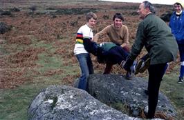 Kevin, John and Colin lay Mark's dead body on the Coffin Stone