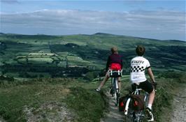 Martin Burrows and Adam Nice on the rough track from Hamel Down to Widecombe, with Widecombe Church below